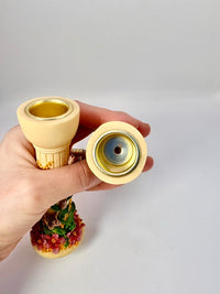 Hand holding a decorative hookah with floral design on a white background