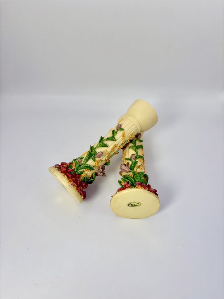 Decorative candle holders with greenery and red berries on a white background