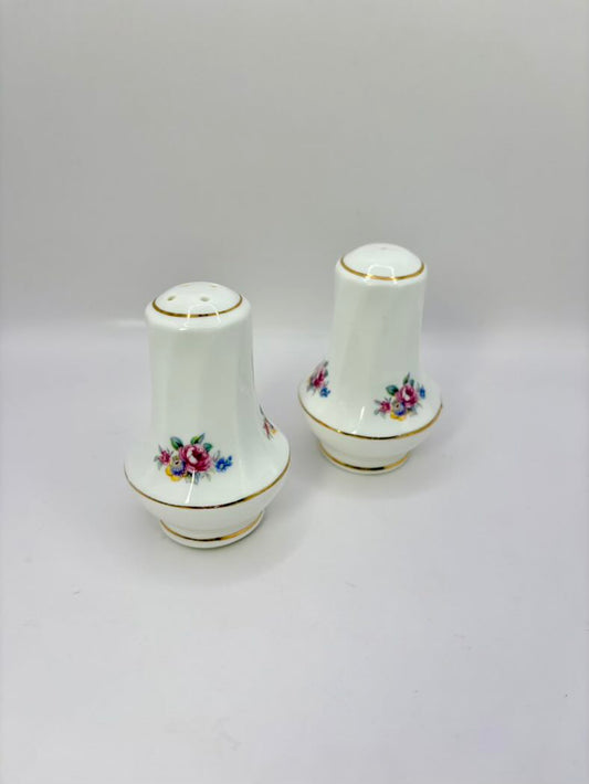 Two ceramic salt and pepper shakers with floral designs on a white background