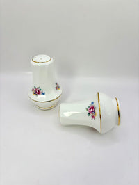 Two ceramic salt and pepper shakers with floral designs on a white background