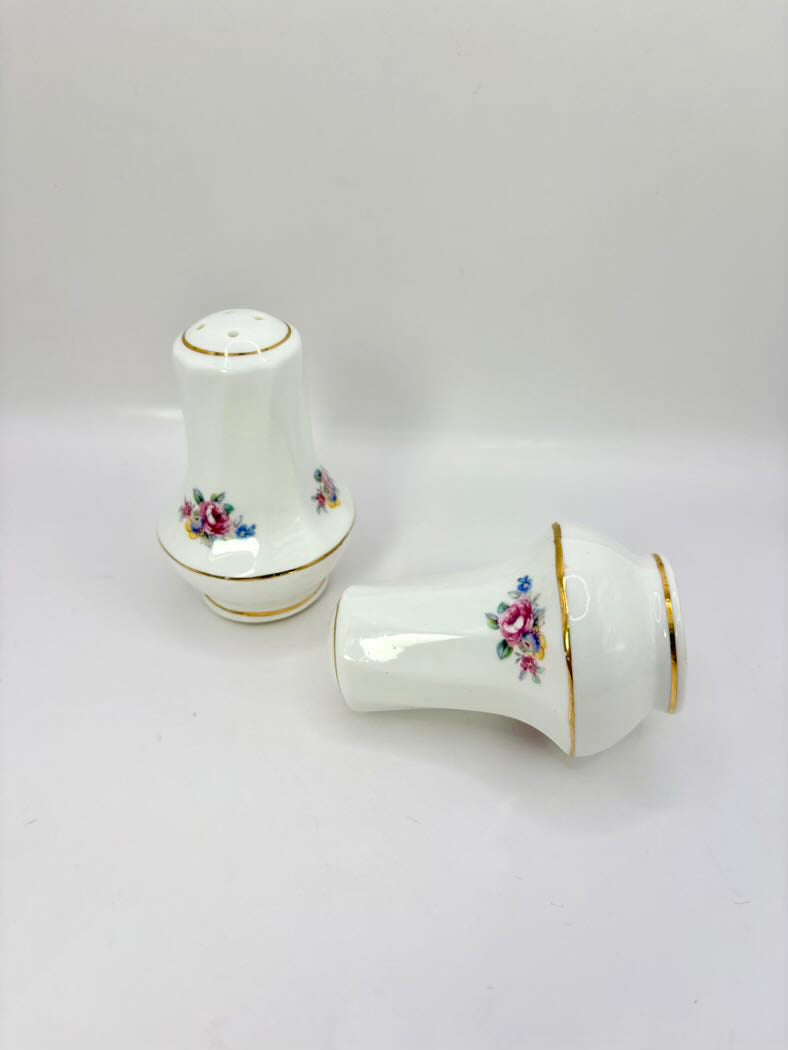 Two ceramic salt and pepper shakers with floral designs on a white background
