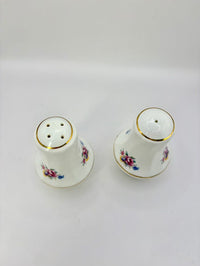 Two ceramic salt and pepper shakers with floral designs on a white background