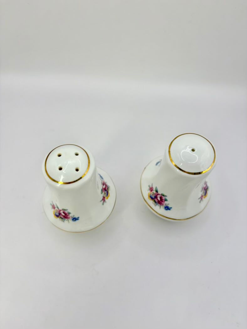 Two ceramic salt and pepper shakers with floral designs on a white background