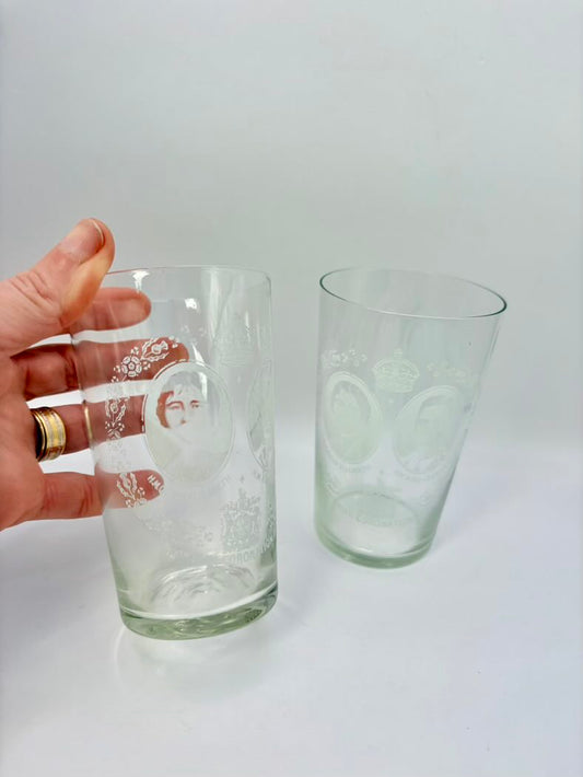 Two clear glasses with embossed designs on a white background