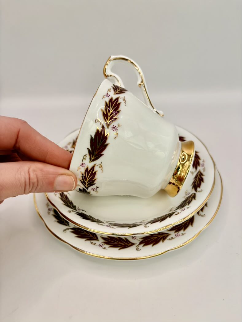 Teacup with gold and brown leaf patterns on a white background