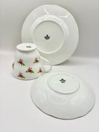 White ceramic teacup and saucer set with floral design on a white background