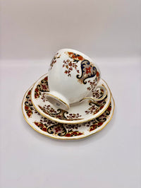 Ceramic cup and saucer set with intricate floral patterns on a white background