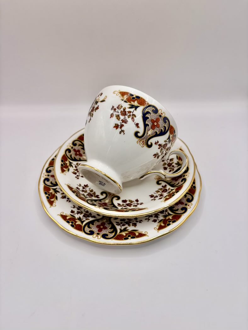 Ceramic cup and saucer set with intricate floral patterns on a white background