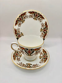Tea cup and saucer set with intricate gold and brown patterns on a white background