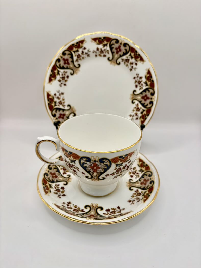 Tea cup and saucer set with intricate gold and brown patterns on a white background