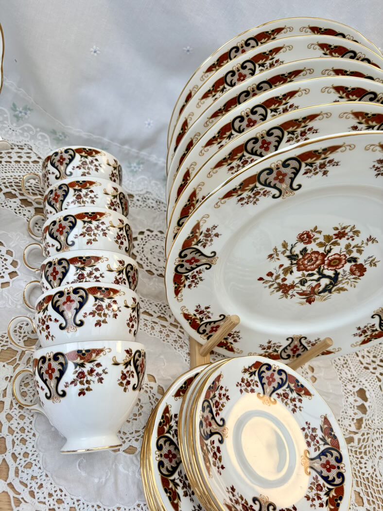 Set of ceramic dishes with floral patterns on a lace tablecloth