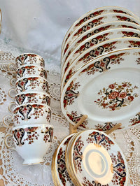 Set of ceramic dishes with floral patterns on a lace tablecloth