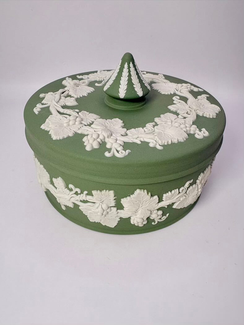 Green ceramic box with white floral patterns on a white background