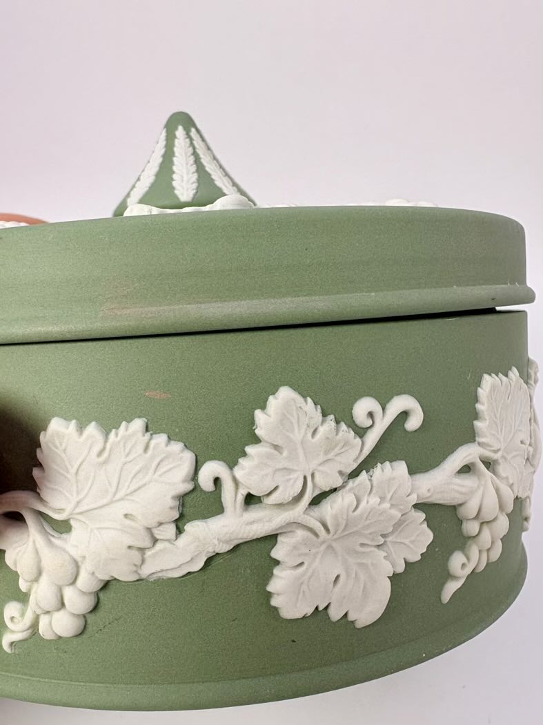 Green ceramic box with white floral patterns on a white background