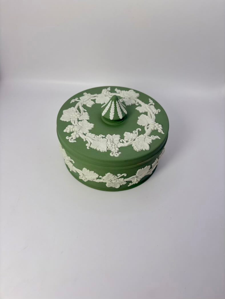 Green decorative box with white floral patterns on a white background