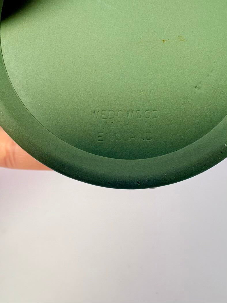 Green ceramic plate with 'WEDGWOOD' branding on a light gray background