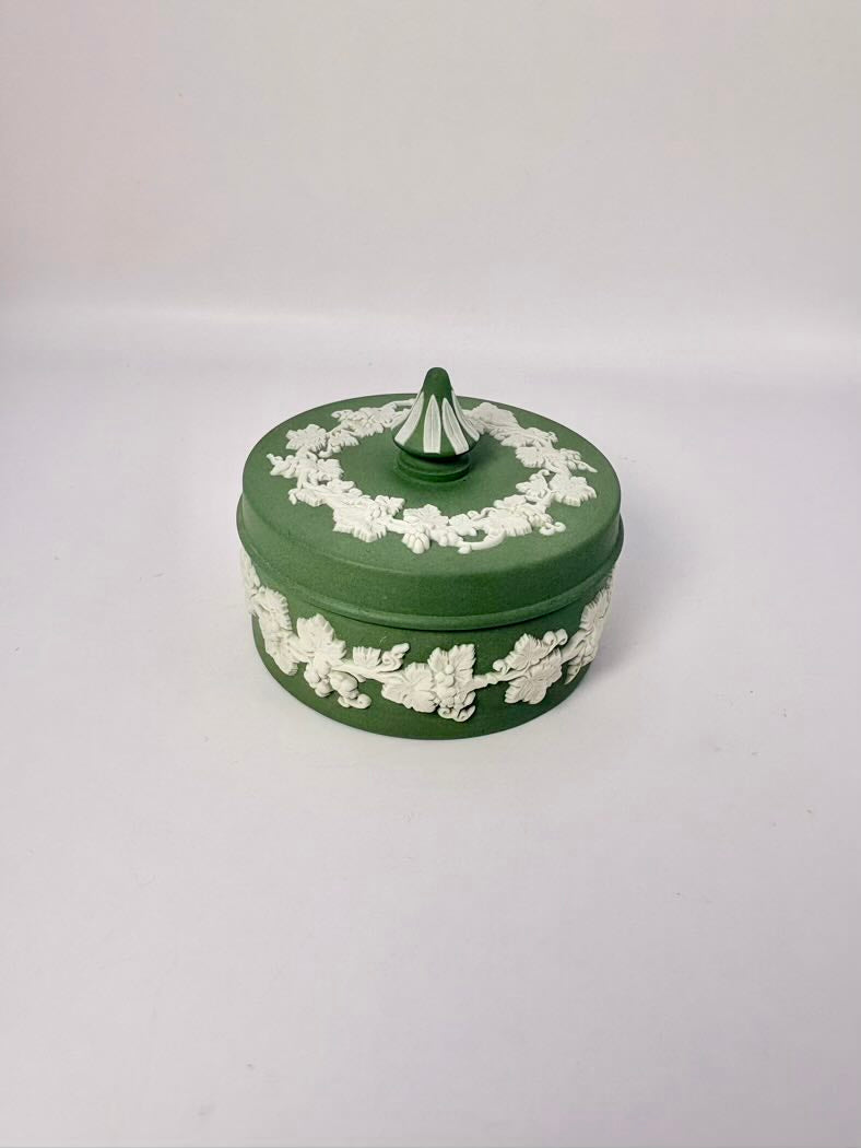 Green decorative box with white floral patterns on a white background