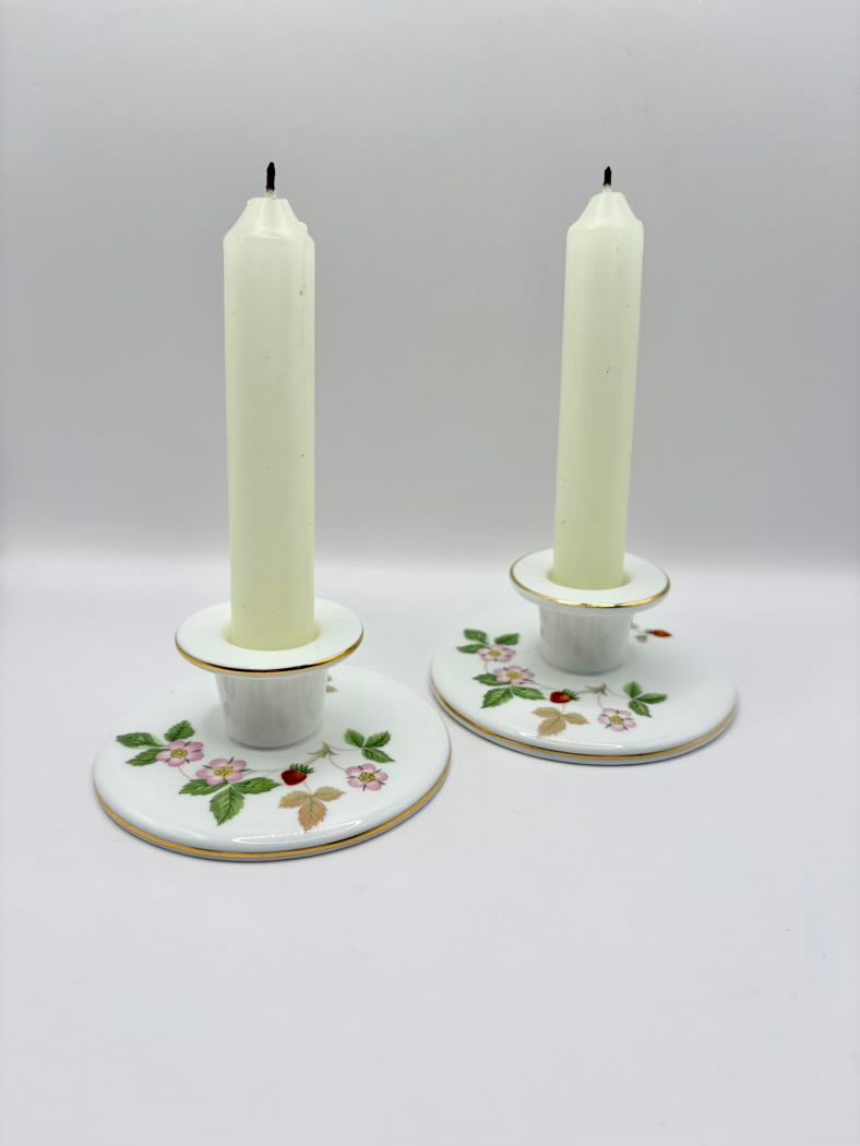 Two candle holders with candles on a white background