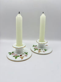 Two candle holders with candles on a white background