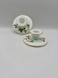 White ceramic candle holder with floral design on a white background