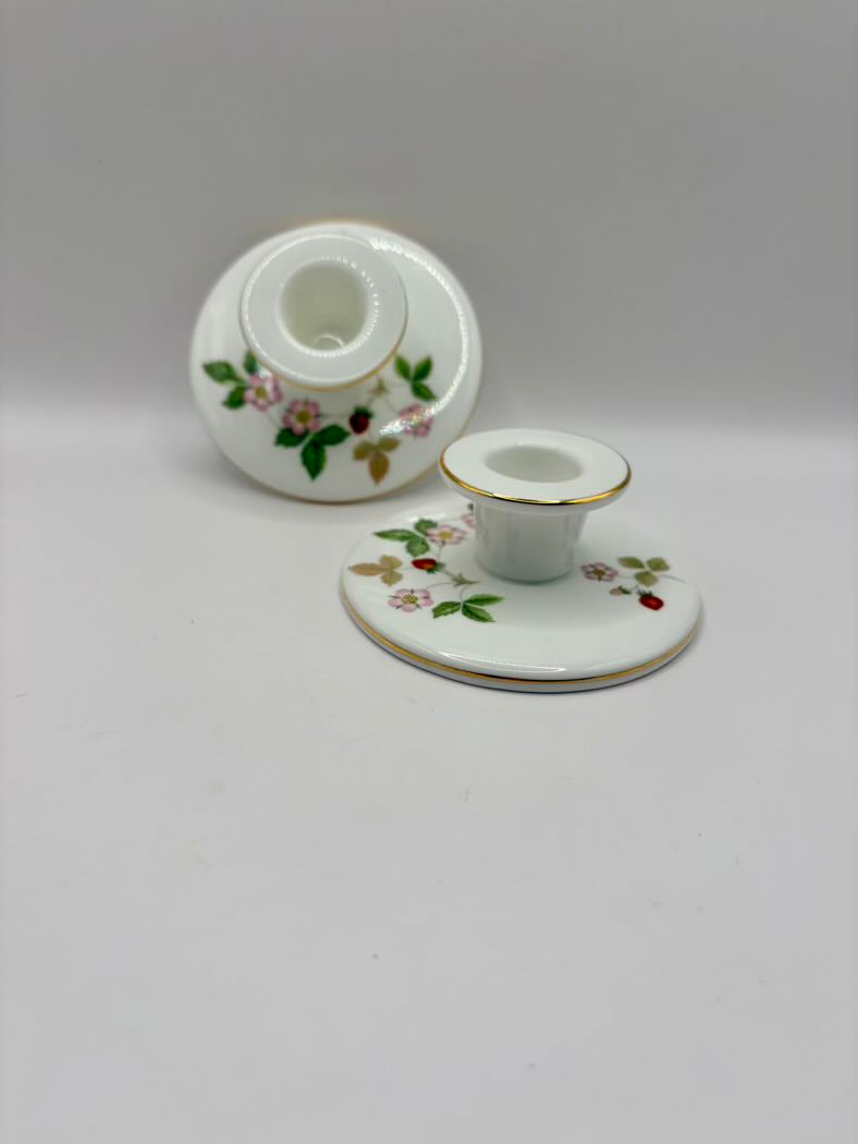 White ceramic candle holder with floral design on a white background