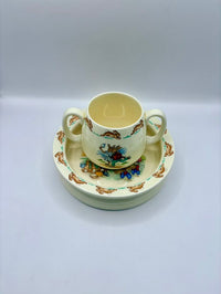 Ceramic cup and saucer set with floral design on a white background