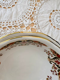 Decorative ceramic plate with intricate patterns on a lace tablecloth