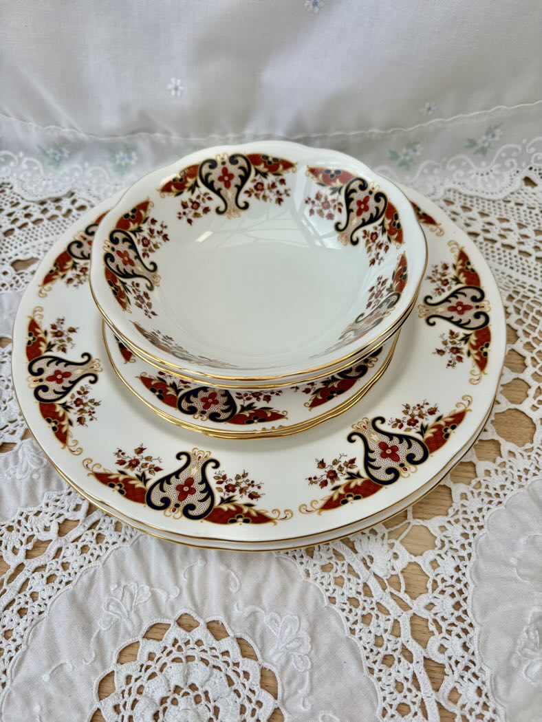 Set of decorative ceramic plates with intricate patterns on a lace tablecloth.