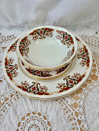Set of decorative ceramic plates with intricate patterns on a lace tablecloth.