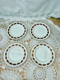 Set of four ceramic plates with decorative edge on a lace tablecloth