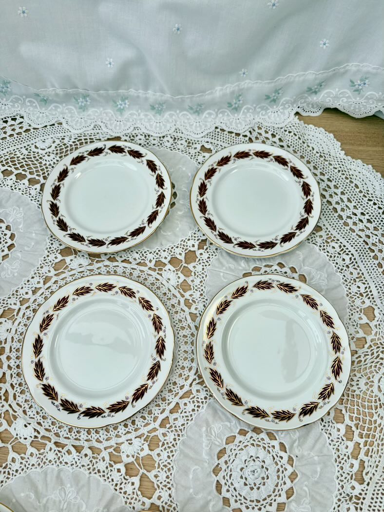 Set of four ceramic plates with decorative edge on a lace tablecloth