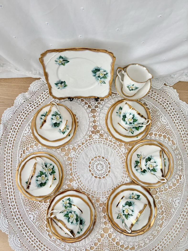 Set of decorative ceramic plates with floral patterns on a lace tablecloth.