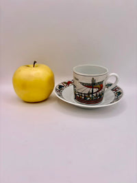 Ceramic cup with saucer and yellow apple on a white background