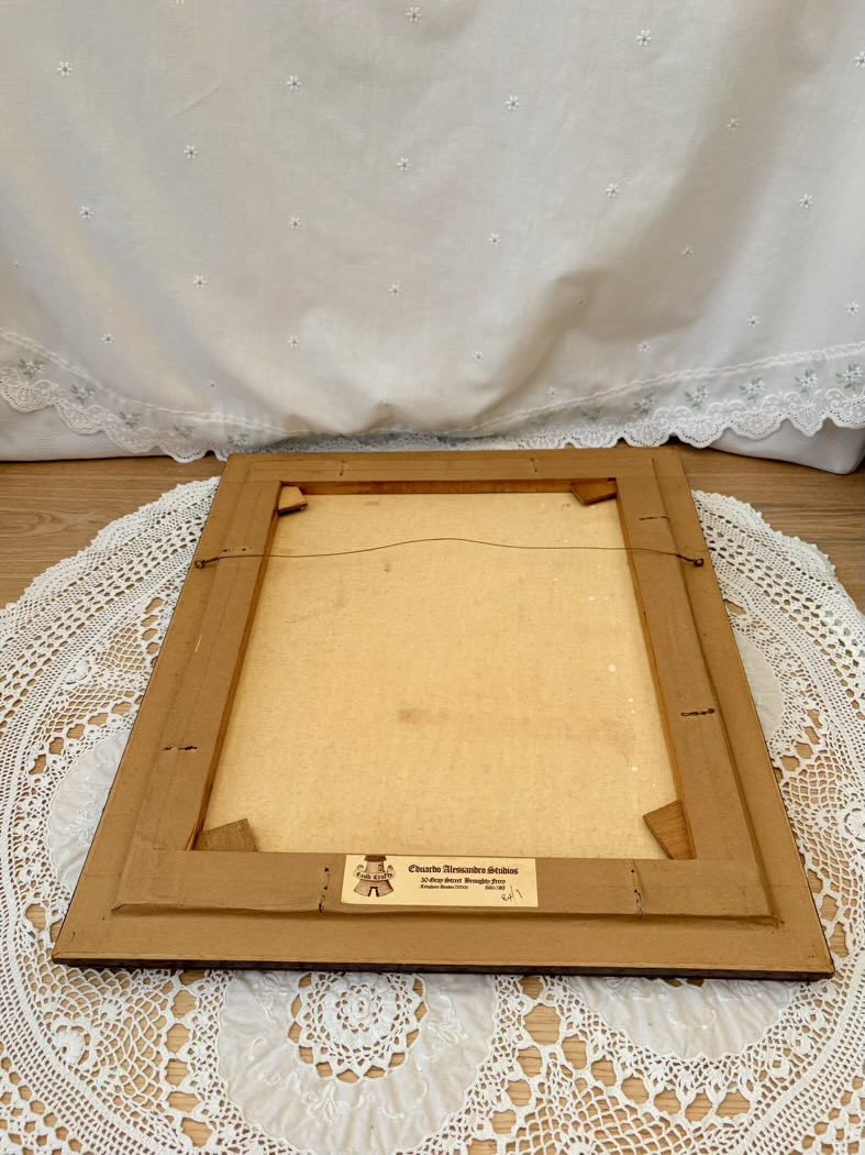 Wooden picture frame on a lace tablecloth with a white curtain in the background