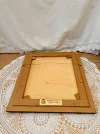 Wooden picture frame on a lace tablecloth with a white curtain in the background