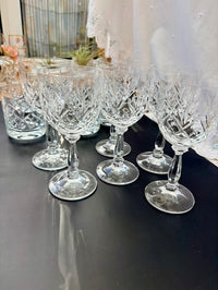 Set of crystal wine glasses on a dark surface with blurred background
