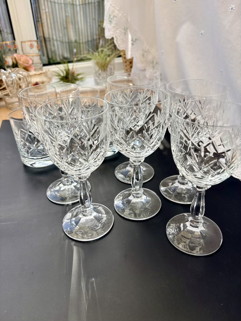 Set of crystal glasses on a reflective surface with blurred background