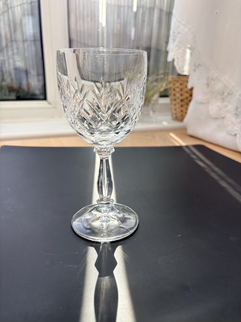 Crystal wine glass on a dark surface with a blurred background
