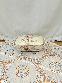 Decorative ceramic dish with floral patterns on a lace tablecloth