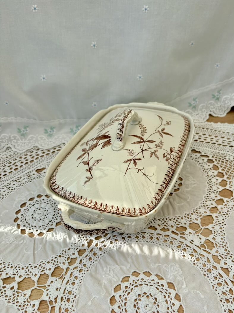 Decorative ceramic dish with floral patterns on a lace tablecloth