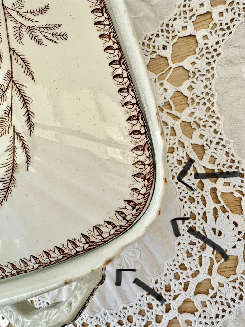 Close-up of a ceramic plate with decorative edge and lace doily underneath