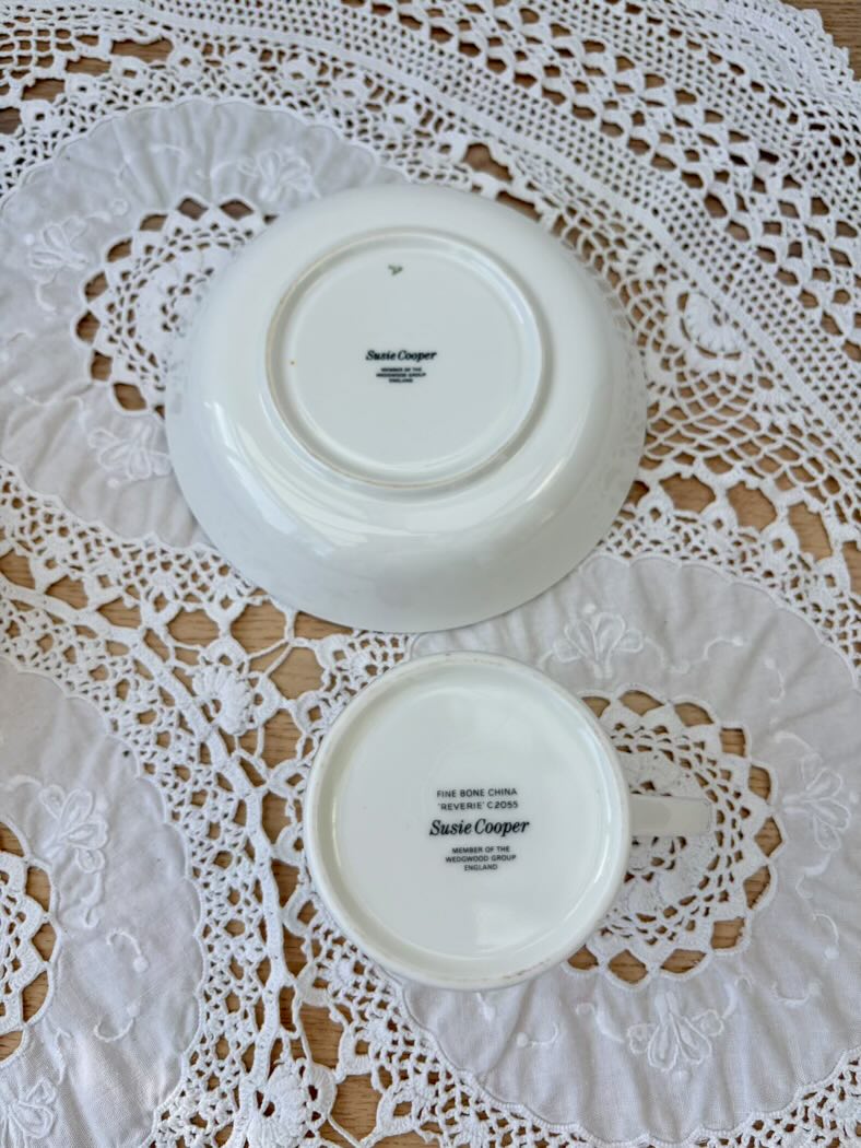 Two white plates with 'Saul Cooper' branding on a lace doily.