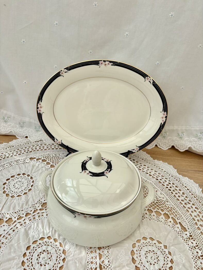 White enameled pot with black trim on a lace tablecloth