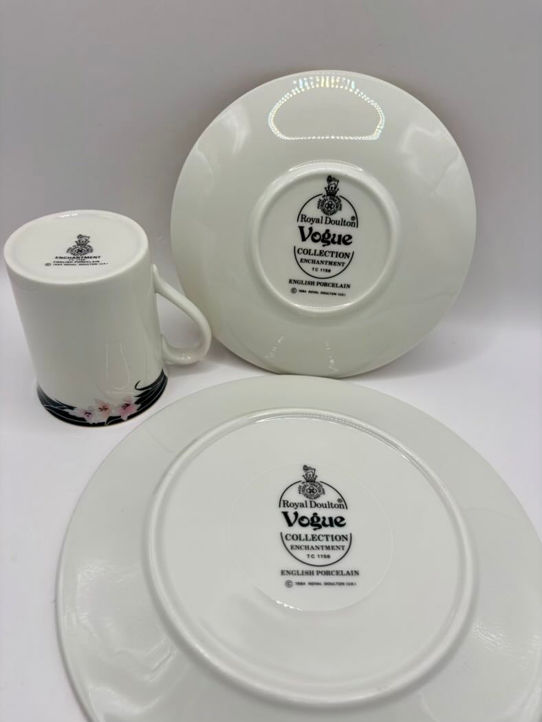 Ceramic mug and two plates with 'Vogue Collection' branding on a white background