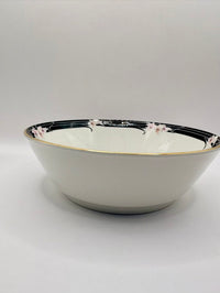 White ceramic bowl with black rim and floral patterns on a white background