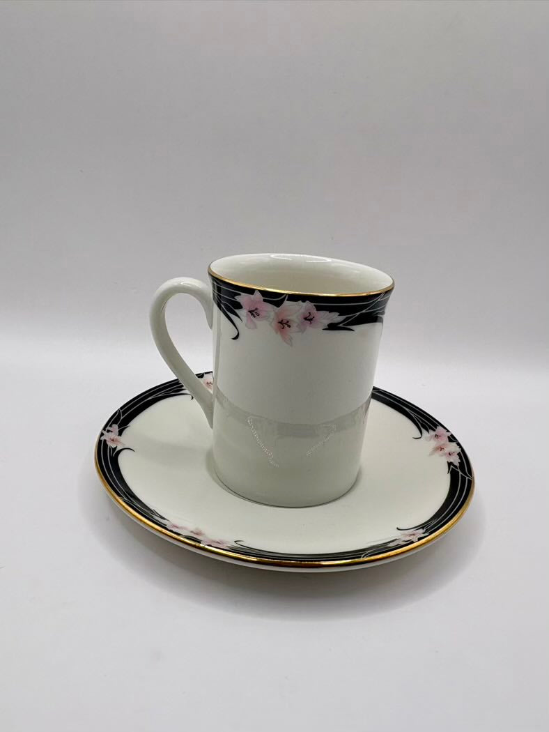 Ceramic cup and saucer with floral design on a white background