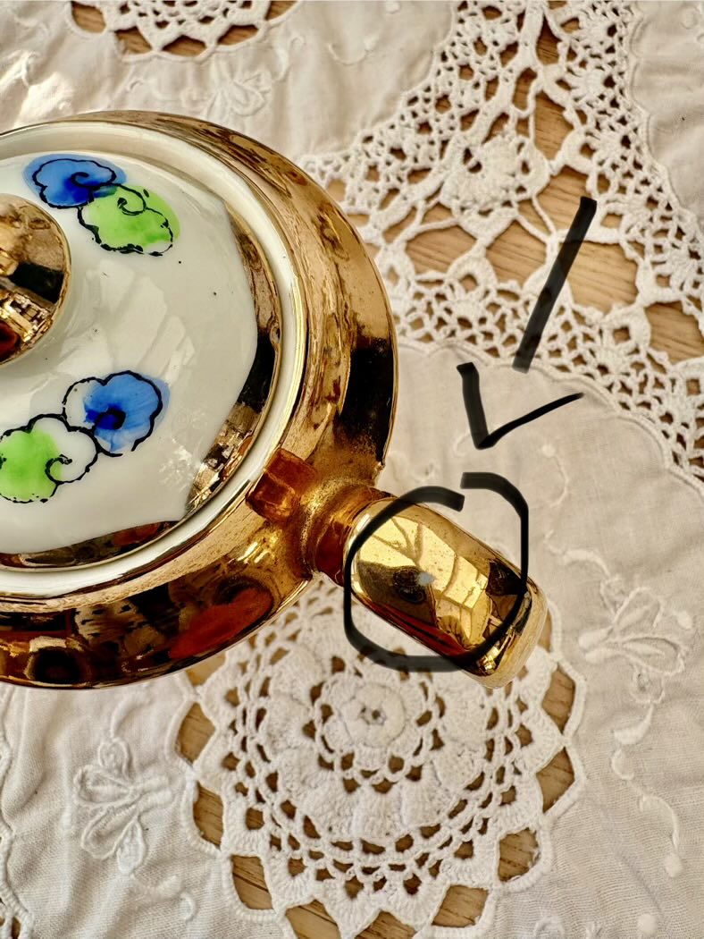 Decorative teapot with floral design on a lace doily