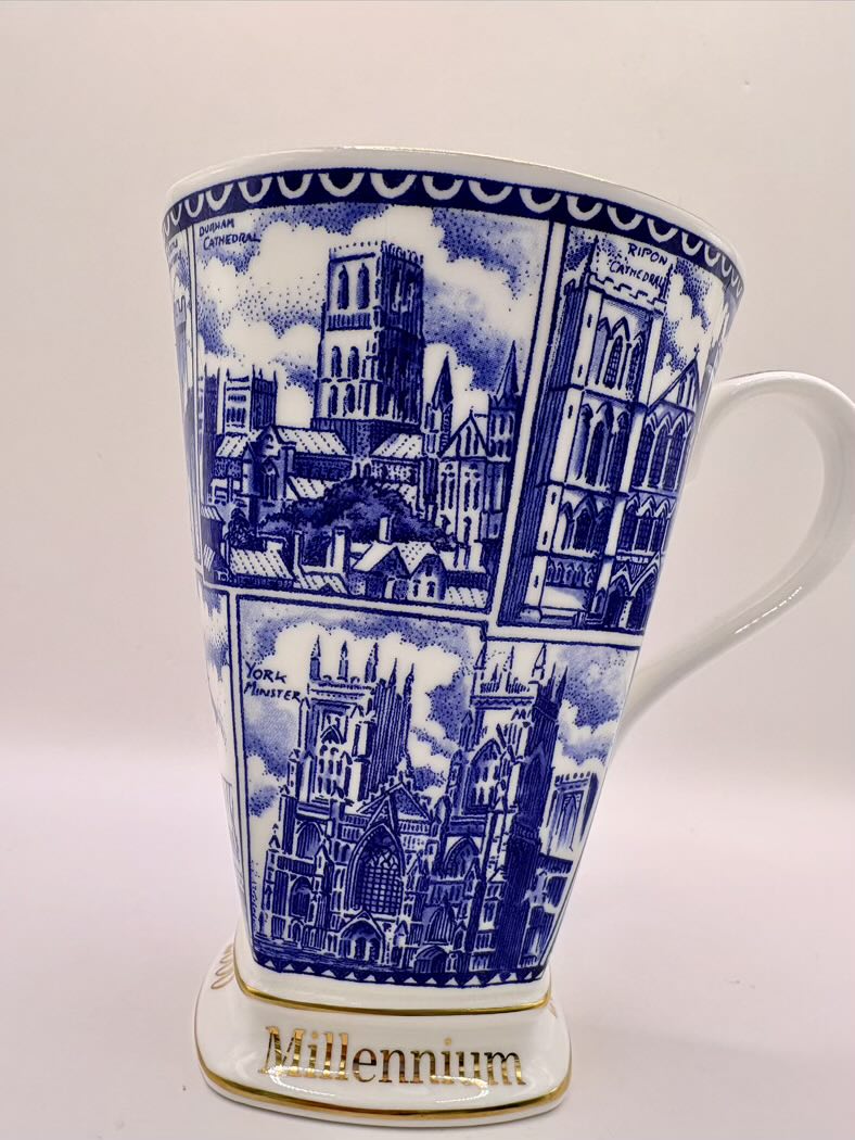 Ceramic mug with blue architectural design and 'Millennium' text on a white background