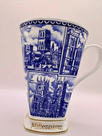Ceramic mug with blue architectural design and 'Millennium' text on a white background