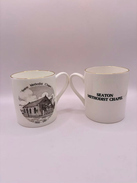 Two white mugs with 'Seaton Methodist Chapel' text and graphic on a white background